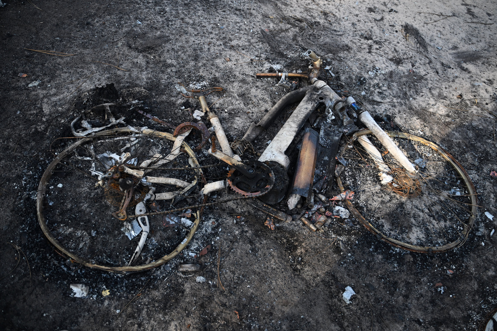 A bicycle lays charred on the ground at a campsite after wildfires raged in Lège-Cap-Ferret, outside Bordeaux, France, Monday, July 27, 2026. (AP Photo/Emma Da Silva)