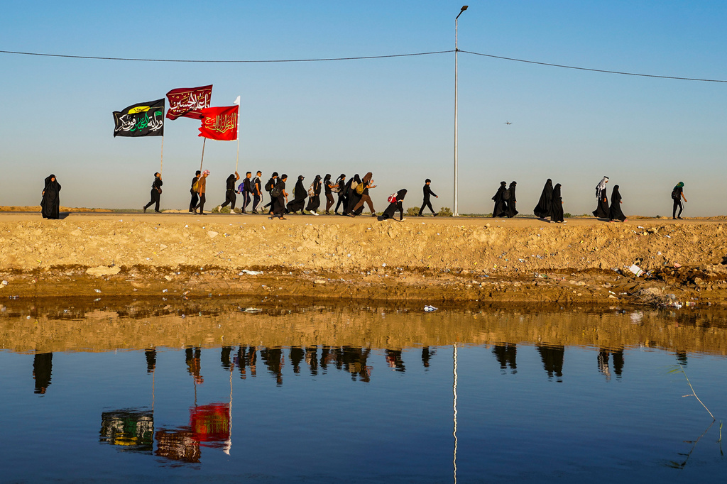 Shiite pilgrims march to Karbala, to observe Arbaeen that marks the end of a 40-day mourning period following the Day of Ashura, in Najaf, Iraq, Tuesday, July 28, 2026. (AP Photo/Anmar Khalil)