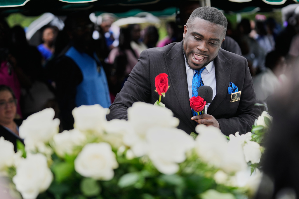 Roses are placed on caskets during the burial of the eight children who were killed during a mass shooting last month, Saturday, May 9, 2026, at Forest Park Cemetery West in Shreveport, La. (AP Photo/Gerald Herbert)