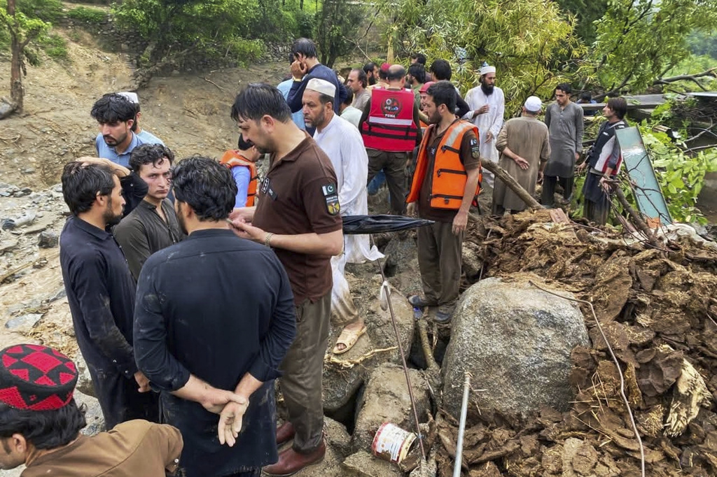 In this photo released by Rescue 1122 Emergency Department, rescue workers and local residents gather at the site of a massive cloudburst led to flash flooding in Salarzai, Pakistan, Friday, Aug. 15, 2025. (Rescue 1122 Emergency Department via AP)