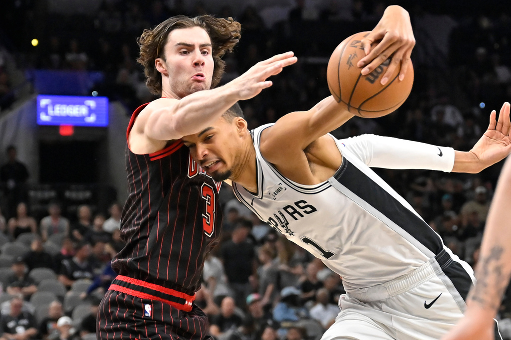 San Antonio Spurs center Victor Wembanyama (1) tangles with Chicago Bulls guard Josh Giddey, left, during the first half of an NBA basketball game, Monday, March 30, 2026, in San Antonio. (AP Photo/Darren Abate)
