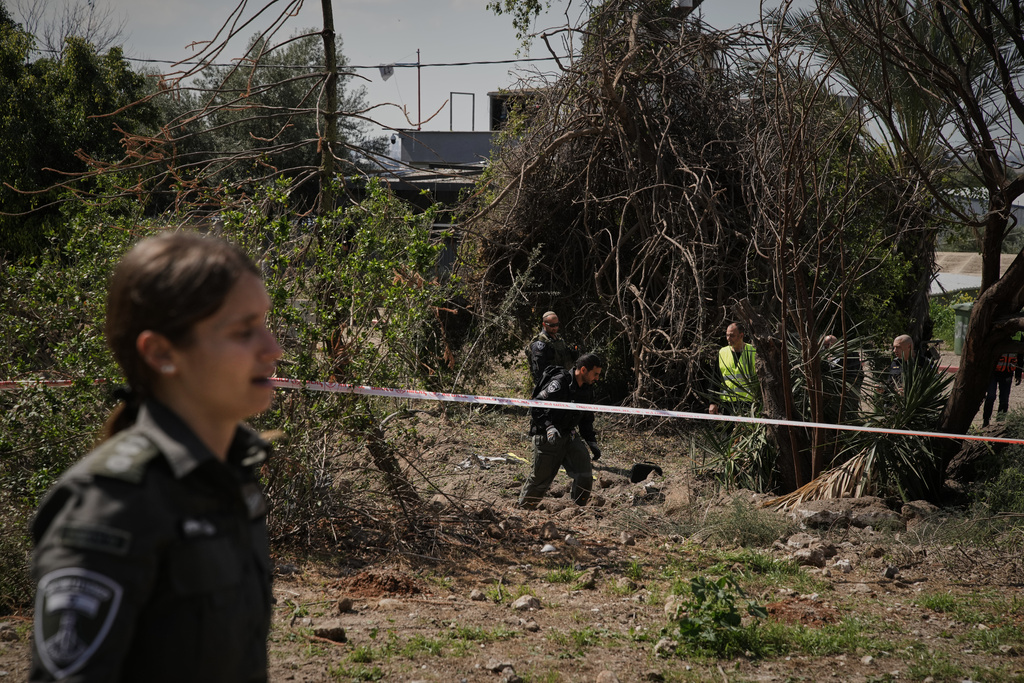 Israeli security forces inspect the site struck by an Iranian missile in central Israel, Thursday, March 5, 2026. (AP Photo/Leo Correa)