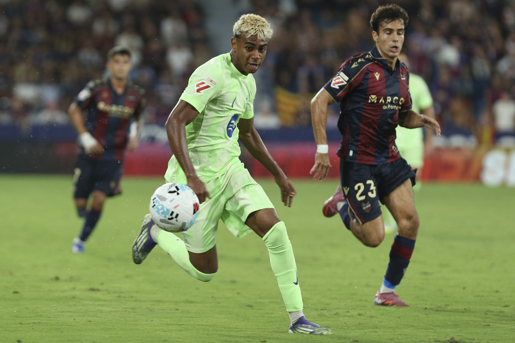Barcelona's Lamine Yamal, left, and Levantes' Pablo Martinez run for the ball during the La Liga soccer match between Levante and Barcelon in Valencia, Spain, Saturday, Aug. 23, 2025. ((AP Photo/Alberto Saiz)