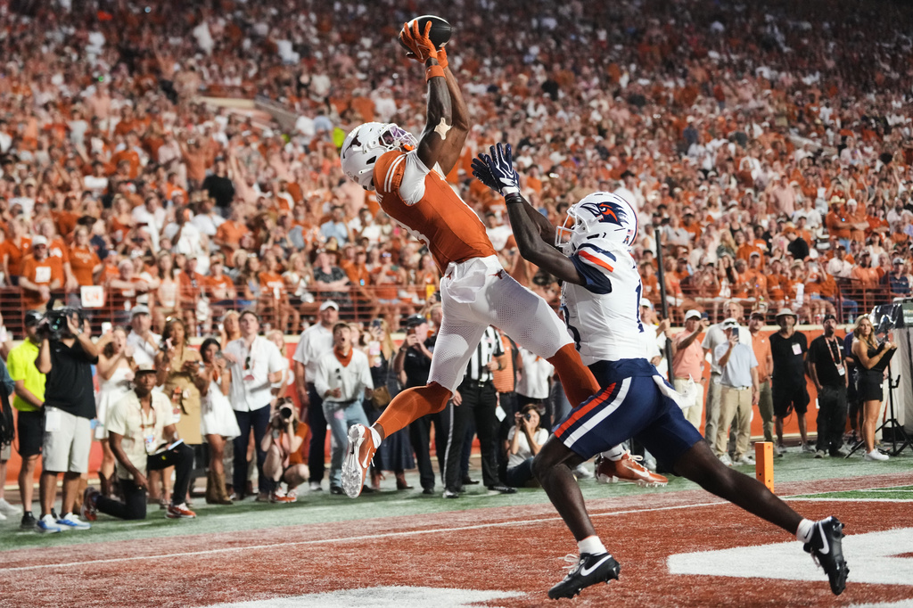 Texas wide receiver Cam Coleman, left, catches a touchdown pass as UTSA cornerback RJ Lester Jr., right, defends during the first half of an NCAA college football game in Austin, Texas, Saturday, Sept. 19, 2026. (AP Photo/Eric Gay)