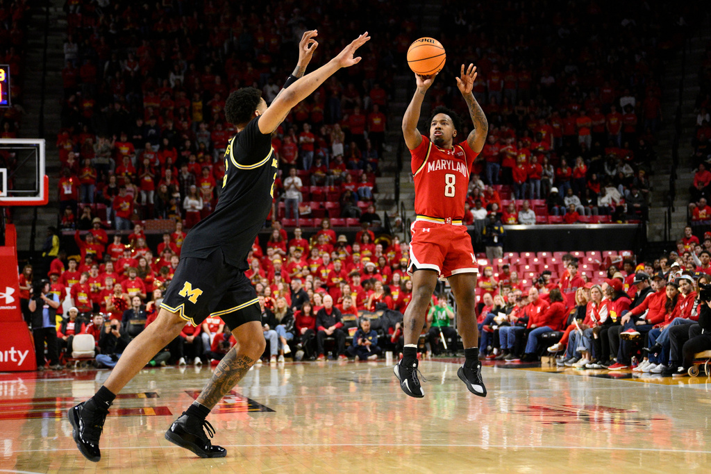 Maryland guard David Coit (8) shoots against Michigan forward Yaxel Lendeborg, left, during the second half of an NCAA college basketball game, Saturday, Dec. 13, 2025, in College Park, Md. (AP Photo/Nick Wass)