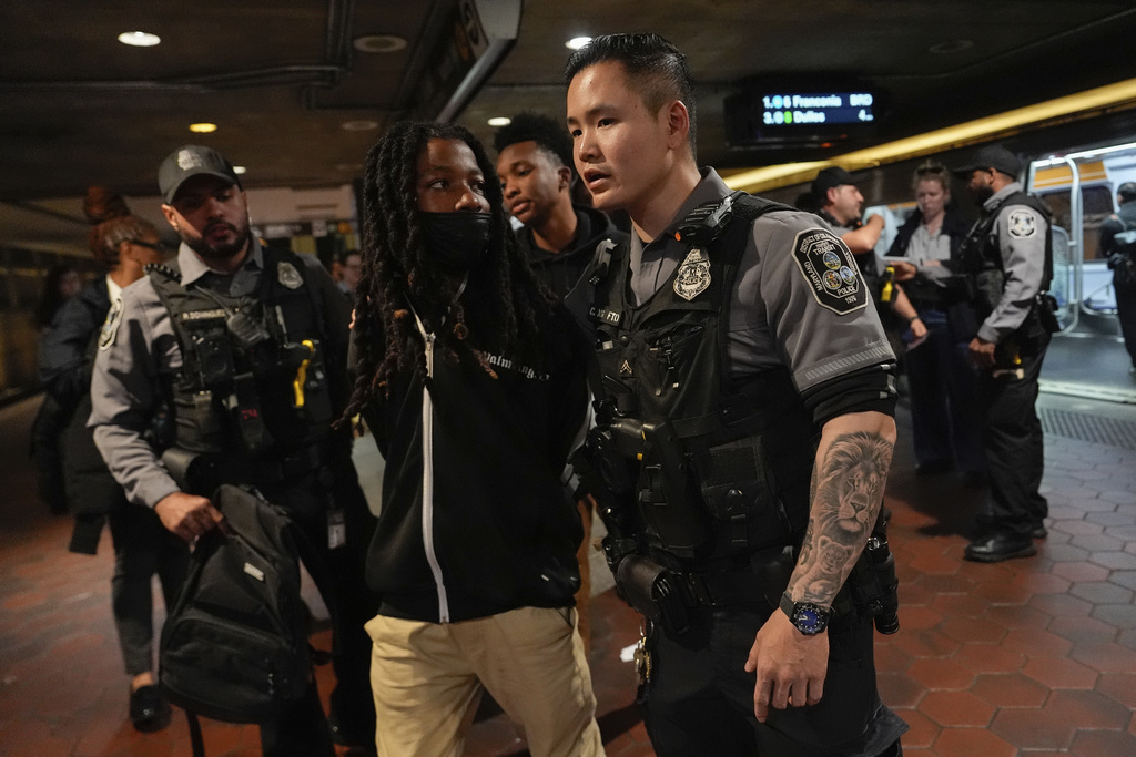 District of Columbia Metro Transit Police Department and Washington Metropolitan Police Department officers detain three people at L'Enfant Plaza metro station, Thursday, Aug. 21, 2025, in Washington. (AP Photo/Julia Demaree Nikhinson)