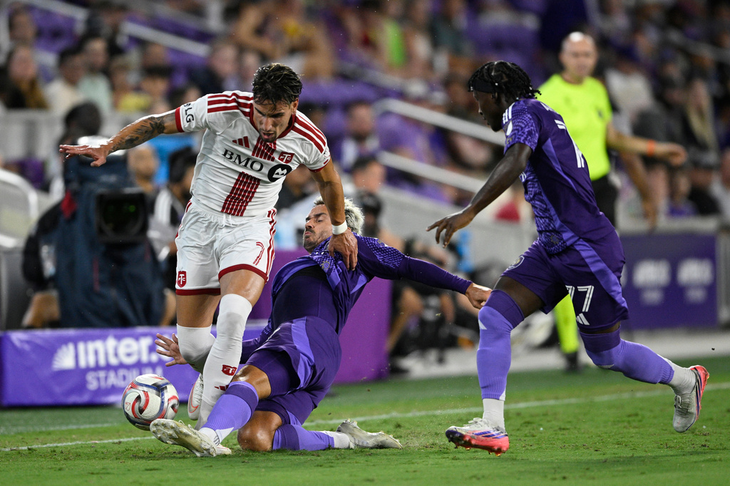 Toronto FC forward Theo Corbeanu (7) competes for the ball with Orlando City forward Antoine Griezmann, center, and midfielder Ivan Angulo (77) during the first half of an MLS soccer match, Saturday, Sept. 12, 2026, in Orlando, Fla. (AP Photo/Phelan M. Ebenhack)