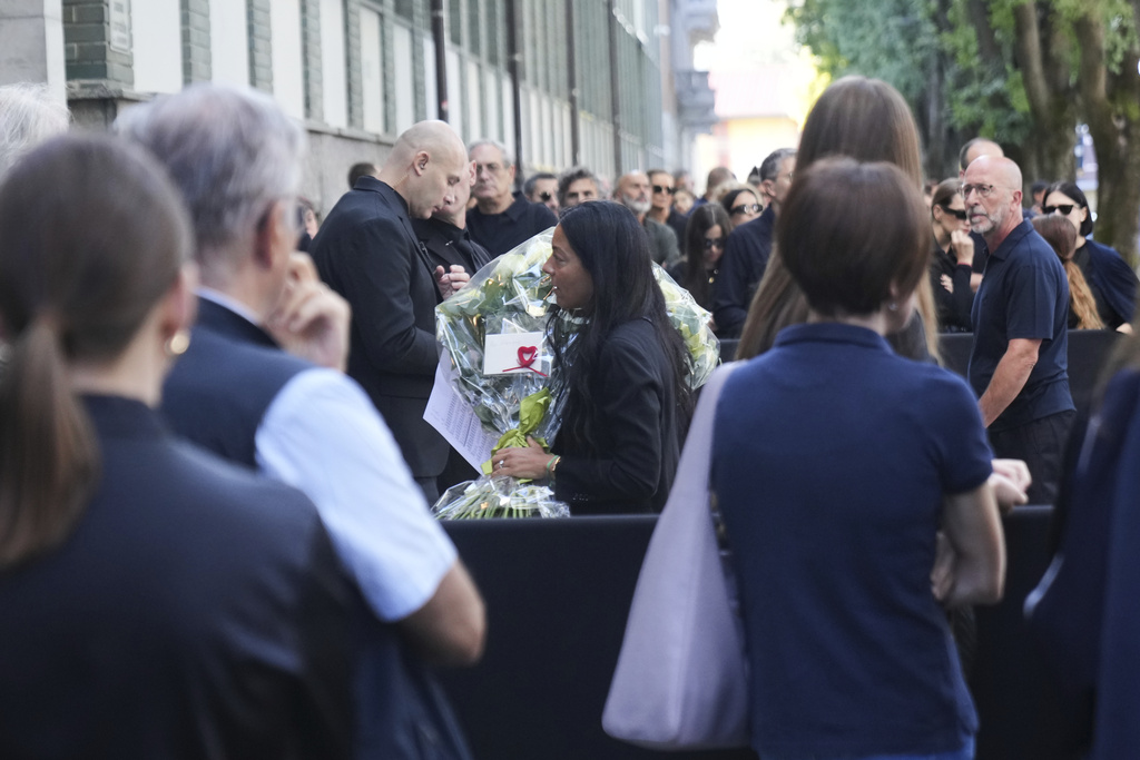 People line up in Milan, northern Italy, Thursday, Sept. 4, 2025, to pay their respects to fashion designer Giorgio Armani, who died Thursday at age 91. (AP Photo/Antonio Calanni)