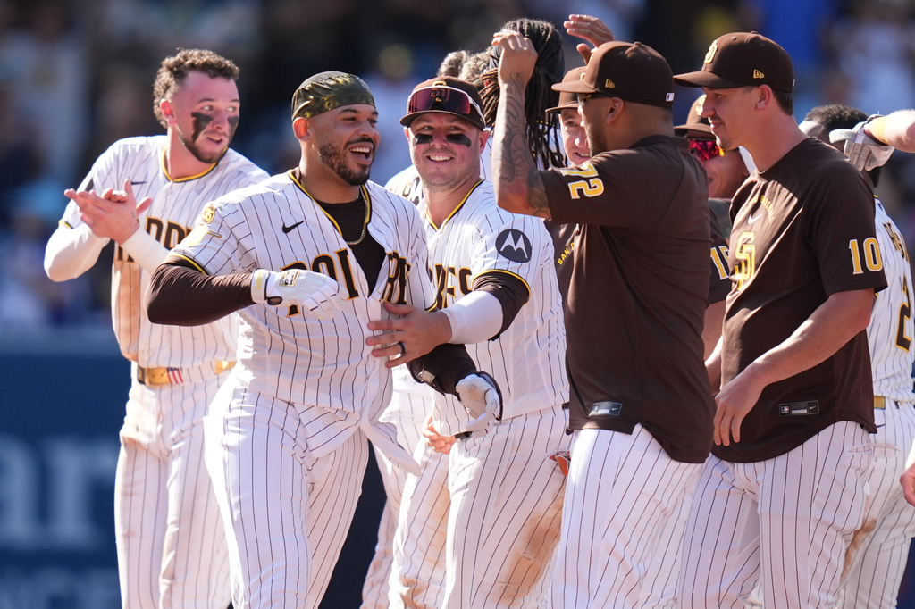 San Diego Padres' Luis Campusano, second from left, celebrates with teammates after hitting a walk off single to defeat the Brewers during the eleventh inning of a baseball game Wednesday, Aug. 12, 2026, in San Diego. (AP Photo/Gregory Bull)
