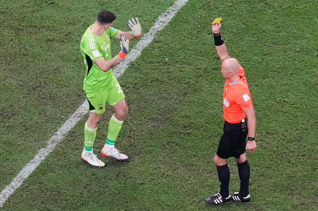 FILE - Referee Szymon Marciniak, of Poland, shows a yellow card to Argentina's goalkeeper Emiliano Martinez during the penalty shootout inthe World Cup final soccer match between Argentina and France at the Lusail Stadium in Lusail, Qatar, Sunday, Dec. 18, 2022. (AP Photo/Thanassis Stavrakis, File)