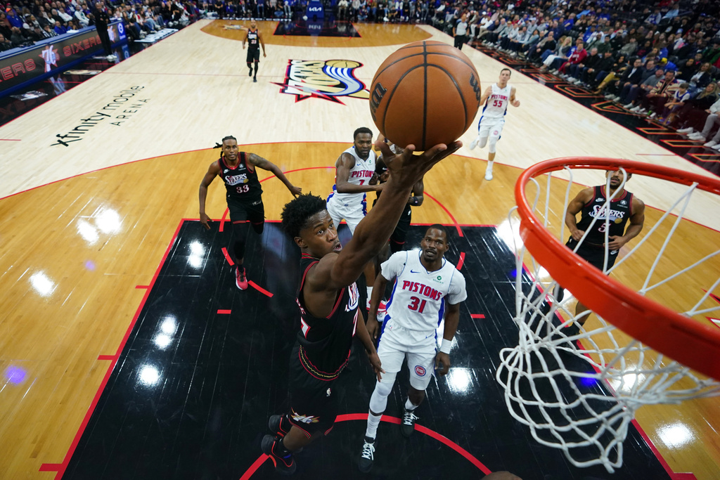 Philadelphia 76ers' VJ Edgecombe, left, goes up for a shot past Detroit Pistons' Javonte Green during the first half of an NBA basketball game Sunday, Nov. 9, 2025, in Philadelphia. (AP Photo/Matt Slocum)