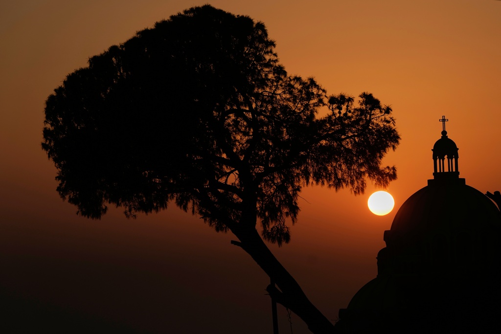 The sun sets behind the dome of the Melkite Greek Catholic Basilica of Saint Paul in Harissa, east of Beirut, Lebanon, Sunday, Nov. 9, 2025. (AP Photo/Hassan Ammar)