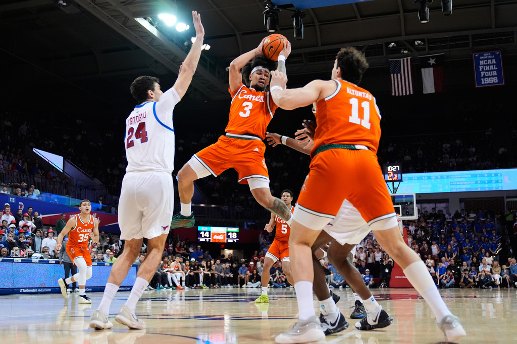Miami guard Tre Donaldson (3) attempts to make a pass in front of Salih Altuntas (11) as SMU's Samet Yigitoglu (24) defends in the first half of an NCAA college basketball game in Dallas, Wednesday, March 4, 2026. (AP Photo/Tony Gutierrez)