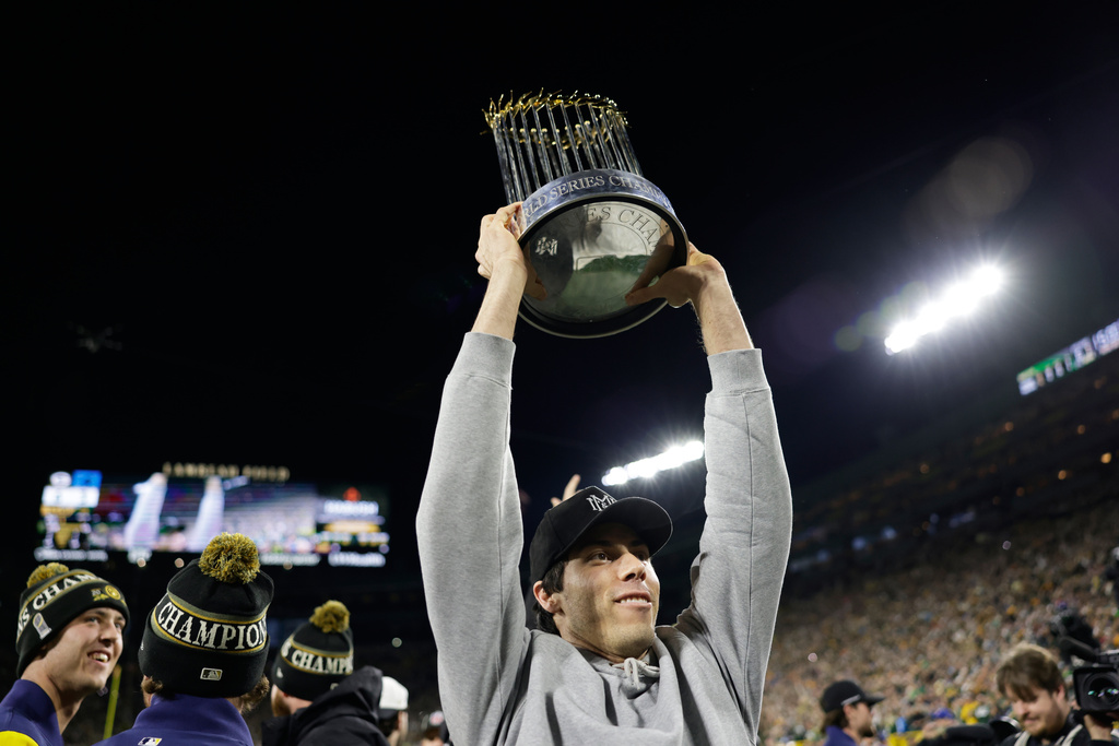 Milwaukee Brewers' Christian Yelich holds up the Commissioner's Trophy during the first half of an NFL football game between the Green Bay Packers and the Carolina Panthers in Green Bay, Wis., Thursday, Oct. 29, 2026. (AP Photo/Matt Ludtke)