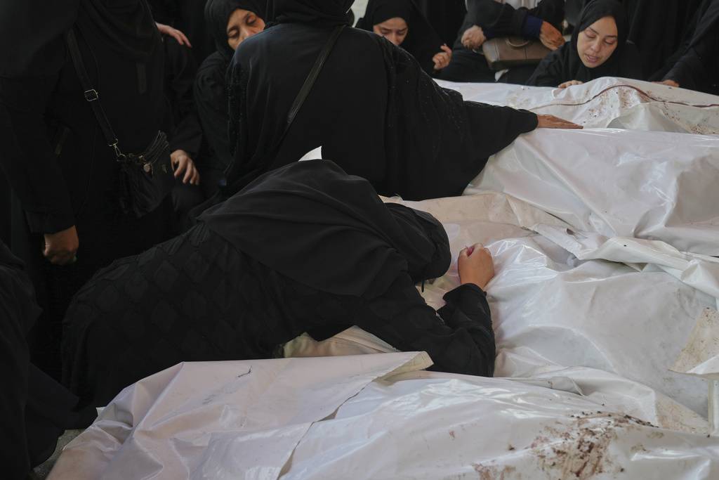 Mourners attend the funeral of their relatives who were killed in an Israeli bombardment, in Deir al-Balah, Gaza Strip, Saturday, July 12, 2025. (AP Photo/Abdel Kareem Hana)