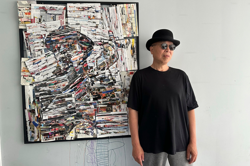 In this photo taken June 2022 and released by Zhao Yaliang, Chinese artist Gao Zhen stands in front of a portrait of himself done by an artist friend on Long Island New York. (Zhao Yaliang via AP)