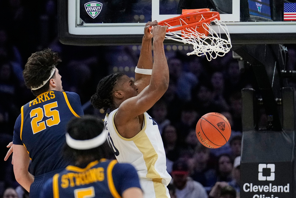 Akron forward Amani Lyles (0) dunks in front of Toledo center Austin Parks (25) in the first half of an NCAA college basketball game in the championship of the Mid-American Conference tournament, Saturday, March 14, 2026, in Cleveland. (AP Photo/Sue Ogrocki)