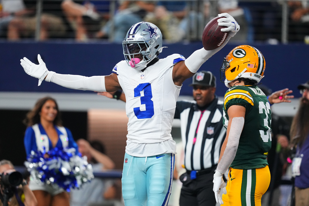 Dallas Cowboys' George Pickens (3) celebrates in front of Green Bay Packers' Evan Williams (33) after Pickens caught a pass late in the first first half of an NFL football game Sunday, Sept. 28, 2025, in Arlington, Texas. (AP Photo/Julio Cortez)