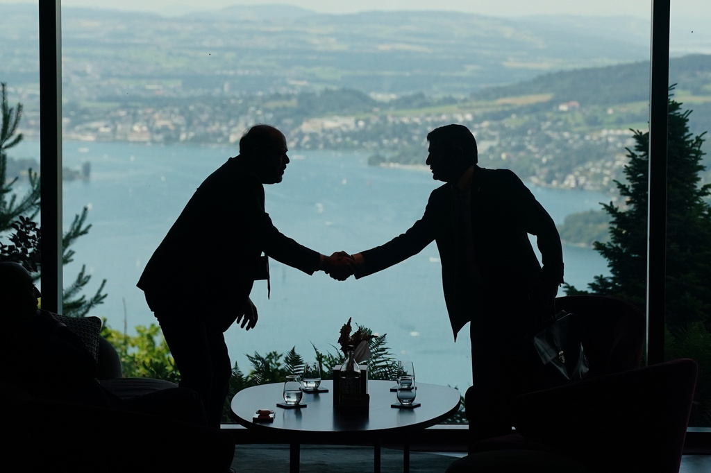 Delegation staff members meet in the lobby on the first day of a quadrilateral meeting between the U.S., Iran, Pakistan, and Qatar at the Buergenstock Resort Lake Lucerne, near Stansstad, Switzerland, Sunday, June 21, 2026. (Nathan Howard/Pool Photo via AP)