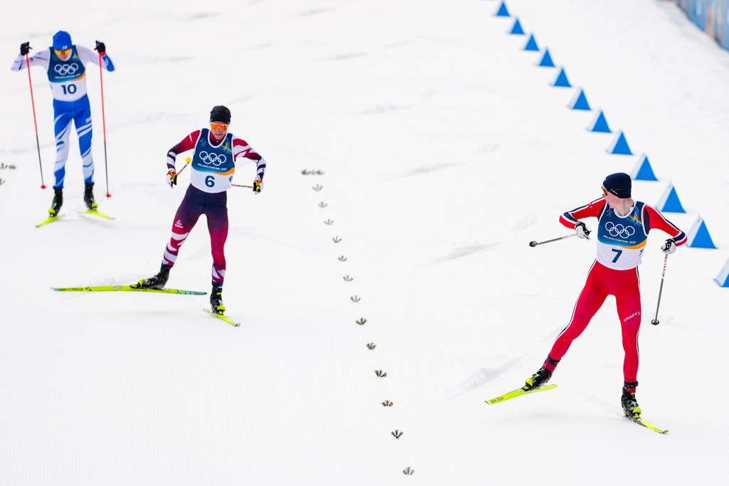 Jens Luraas Oftebro, of Norway, approaches the finish line, followed by Johannes Lamparter, of Austria, and Eero Hirvonen, of Finland, left, to win the gold medal in the Nordic Combined Individual Gundersen Normal Hill/10km competition at the 2026 Winter Olympics, in Tesero, Italy, Wednesday, Feb. 11, 2026. (AP Photo/Kirsty Wigglesworth)