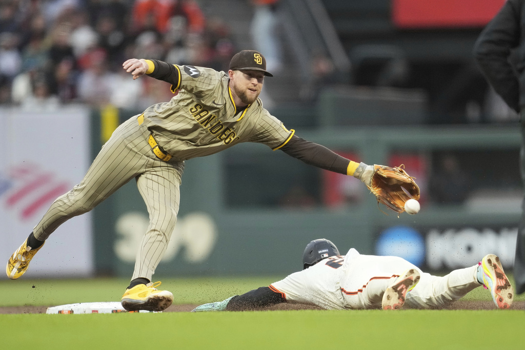 San Francisco Giants' Drew Gilbert, bottom, steals second base under San Diego Padres second baseman Jake Cronenworth during the third inning of a baseball game in San Francisco, Monday, Aug. 11, 2025. (AP Photo/Jeff Chiu)
