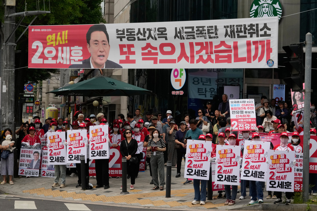 Supporters of Seoul mayoral candidate Oh Se-hoon of the main opposition People Power Party hold signs during an election campaign for June 3 nationwide simultaneous local elections in Seoul, South Korea, Monday, June 1, 2026. (AP Photo/Ahn Young-joon)