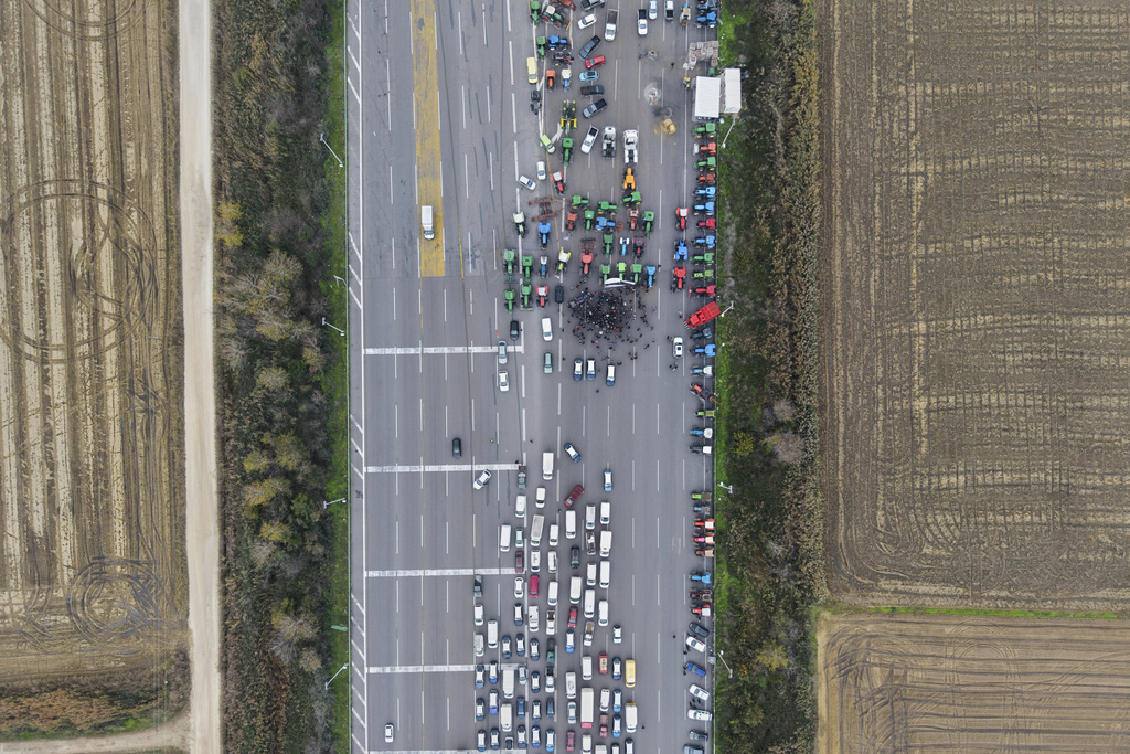 Farmers and supporters block a highway at the Malgara toll stations near Thessaloniki, northern Greece, on Wednesday, Dec. 3, 2025, during a protest over delays in farm subsidy payments. (AP Photo/Giannis Papanikos)