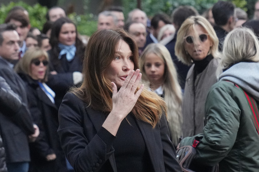 Carla Bruni-Sarkozy blows a kiss as her husband former French President Nicolas Sarkozy heads to prison to serve time for a criminal conspiracy to finance his 2007 election campaign with funds from Libya. Tuesday, Oct. 21, 2025 in Paris. (AP Photo/Thibault Camus) Carla Bruni-Sarkozy blows a kiss as her husband former French President Nicolas Sarkozy heads to prison to serve time for a criminal conspiracy to finance his 2007 election campaign with funds from Libya. Tuesday, Oct. 21, 2025 in Paris. (AP Photo/Thibault Camus)