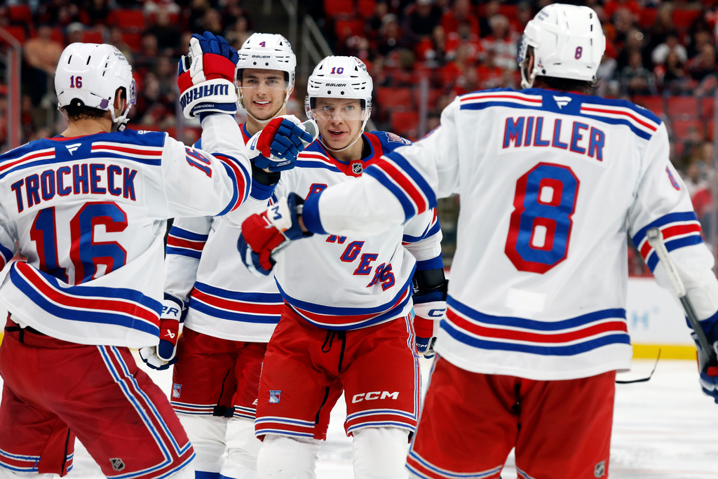 New York Rangers' Artemi Panarin (10), Braden Schneider (4) and J.T. Miller (8) celebrate a goal by Vincent Trocheck (16) during the third period of an NHL hockey game against the Carolina Hurricanes in Raleigh, N.C., Wednesday, Nov. 26, 2025. (AP Photo/Karl DeBlaker)