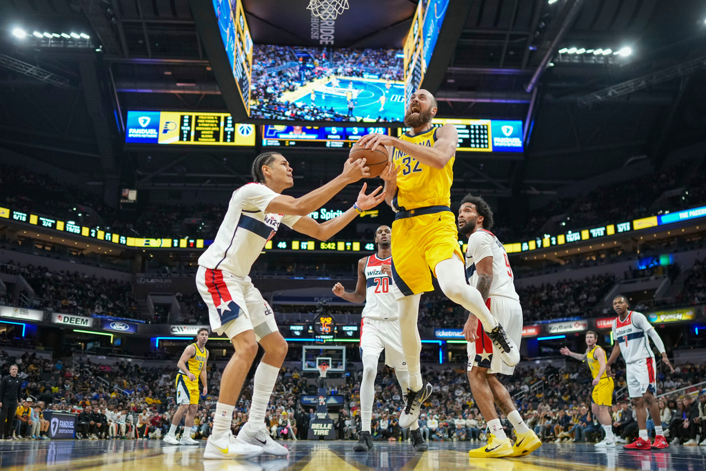 Indiana Pacers center Jay Huff (32) grapples for control of the ball with Washington Wizards forward Kyshawn George during the first half of an NBA Cup basketball game in Indianapolis, Friday, Nov. 28, 2025. (AP Photo/AJ Mast)
