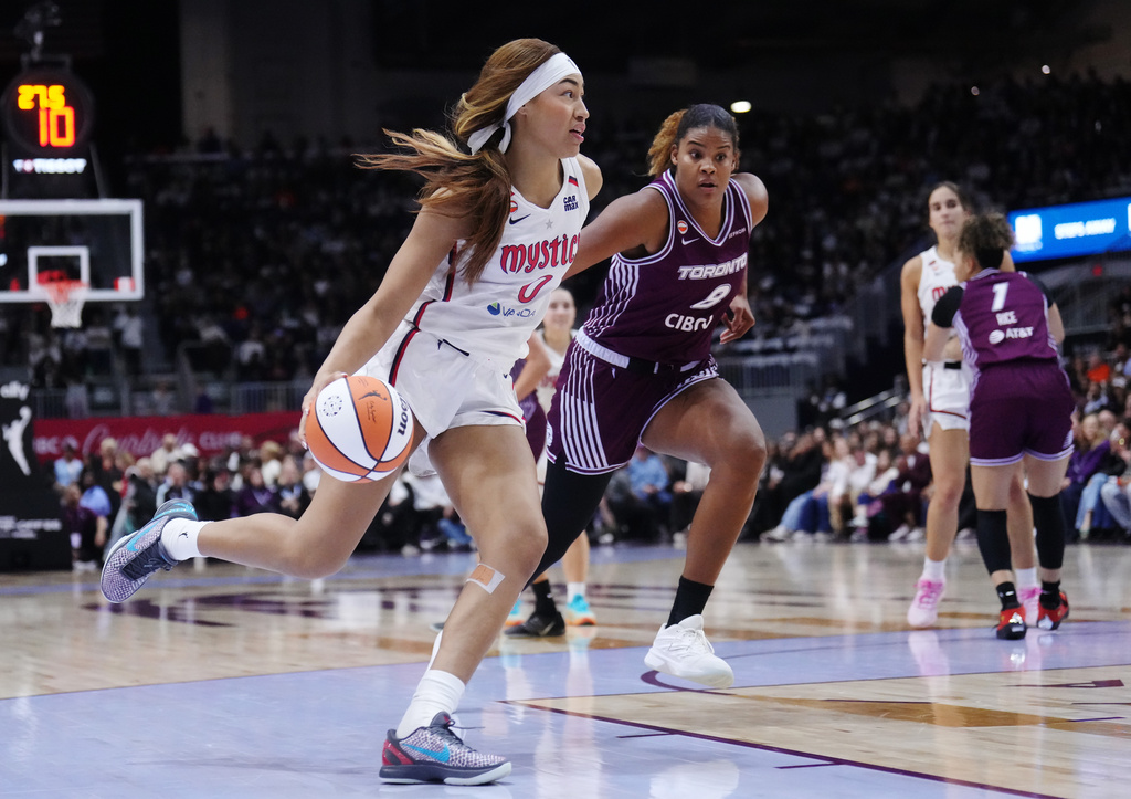 Washington Mystics' Shakira Austin (0) drives past Toronto Tempo's Nyara Sabally (8) during first-half WNBA basketball game action in Toronto, Friday, May 8, 2026. (Nathan Denette/The Canadian Press via AP)