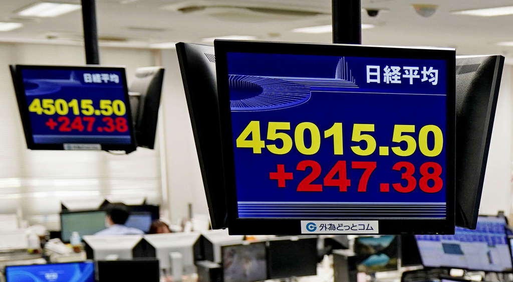 Employees of a foreign exchange dealing company sit under an electronic board showing the stock index of Japan's Nikkei 225, in Tokyo Tuesday, Sept. 16, 2025, in Tokyo. (Kyodo News via AP)