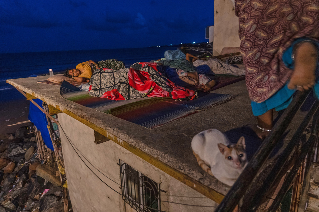 FILE - Residents sleep on the roof of their home near Versova Beach to escape the oppressive heat inside as hot and humid conditions persist amid a delayed monsoon in Mumbai, India, June 19, 2026. (AP Photo/Rafiq Maqbool, File)