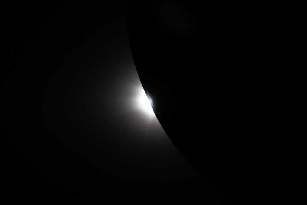In this image provided by NASA, the Artemis II crew captured this image of the Sun beginning to peek out from behind the Moon as an eclipse transitions out of totality during a lunar flyby, Monday, April 6, 2026. NASA via AP)