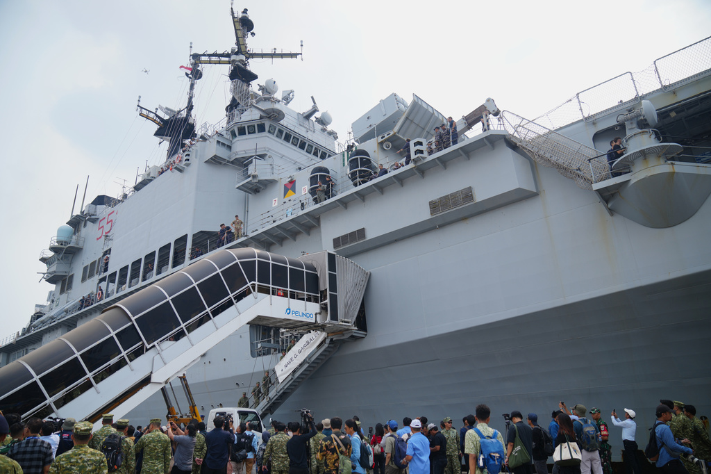 Indonesian military personnel and journalists gather beside the Giuseppe Garibaldi, a former Italian Navy aircraft carrier, after its arrival at Tanjung Priok port in Jakarta, Indonesia, Friday, Sept. 18, 2026. (AP Photo/Tatan Syuflana)