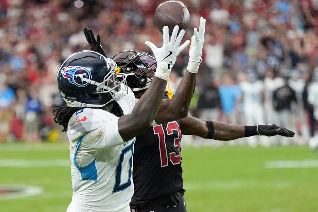 Tennessee Titans wide receiver Calvin Ridley (0) makes a catch past Arizona Cardinals cornerback Kei'Trel Clark (13) during the second half of an NFL football game Sunday, Oct. 5, 2025, in Glendale, Ariz. (AP Photo/Ross D. Franklin)
