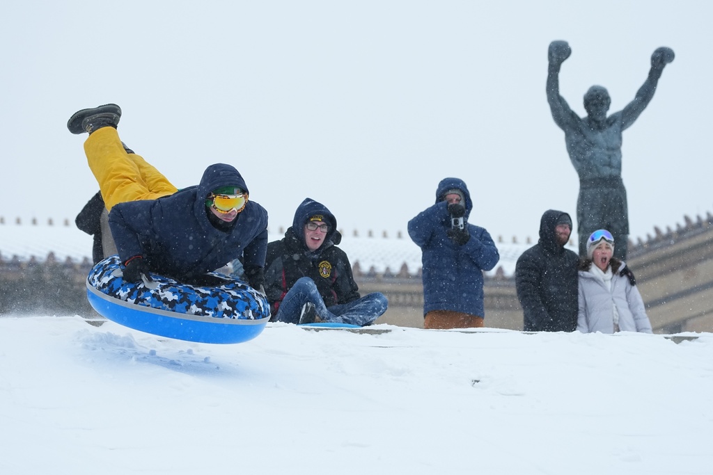 People sled at Philadelphia Art Museum steps by the Rocky statue during a winter storm in Philadelphia, Sunday, Jan. 25, 2026. (AP Photo/Matt Rourke)