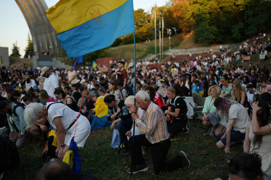 People stand still for a minute of silence during a rally to protest against the dismissal of Mykhailo Fedorov as Ukraine's Defense Minister in Kyiv, Sunday, Aug. 16, 2026. (AP Photo/Francisco Seco)