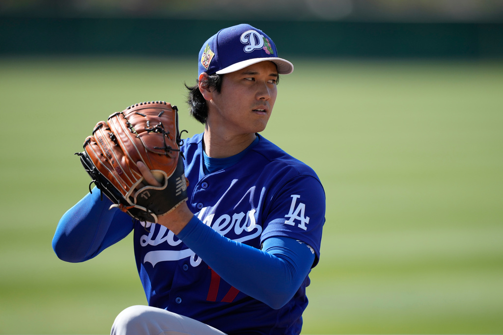 Los Angeles Dodgers two-way player Shohei Ohtani (17) warms up during spring training baseball on Sunday, Feb. 22, 2026, in Phoenix. (AP Photo/Brynn Anderson)