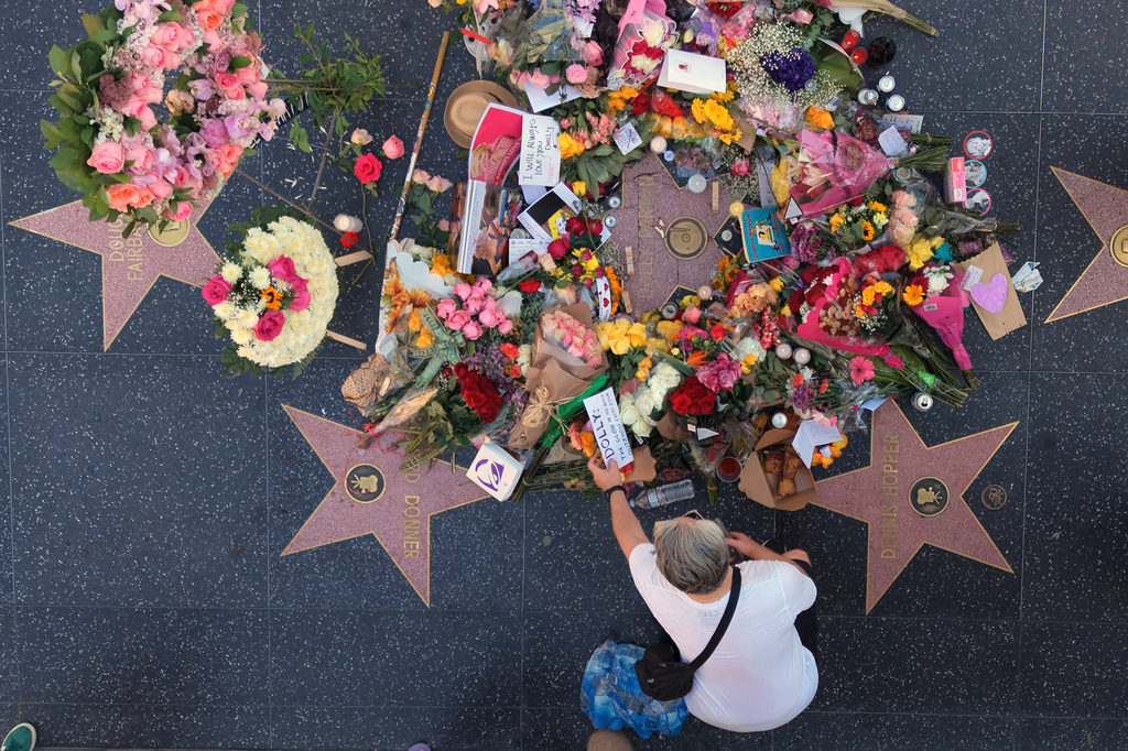 In This aerial view, flowers, notes and photos are left on Dolly Parton's star on the Hollywood Walk of Fame on Wednesday, Aug. 26, 2026, in Los Angeles. (AP Photo/Jae C. Hong)