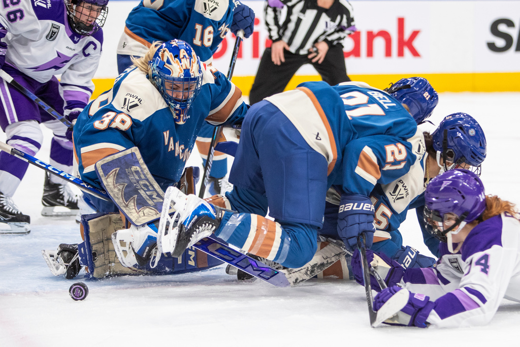 Vancouver Goldeneyes goalie Emerance Maschmeyer (38) keeps out Minnesota Frost Dominique Petrie as Kendall Coyne-Schofield (26) looks on and Ashton Bell (21) and Gabby Rosenthal look for the puck during the first period of a PWHL hockey game in Edmonton, Alberta, Saturday Dec. 27, 2025. (Amber Bracken/The Canadian Press via AP)