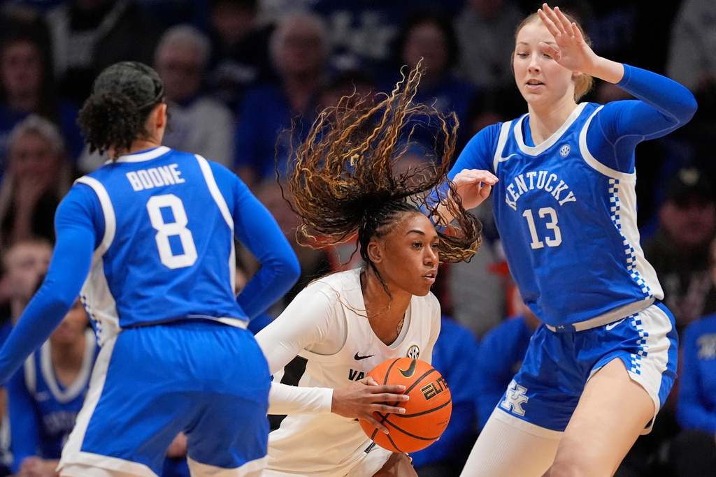 Vanderbilt guard Mikayla Blakes, center, looks to pass the ball past Kentucky guard Asia Boone (8) and center Clara Strack (13) during the first half of an NCAA college basketball game Sunday, Feb. 22, 2026, in Nashville, Tenn. (AP Photo/George Walker IV)