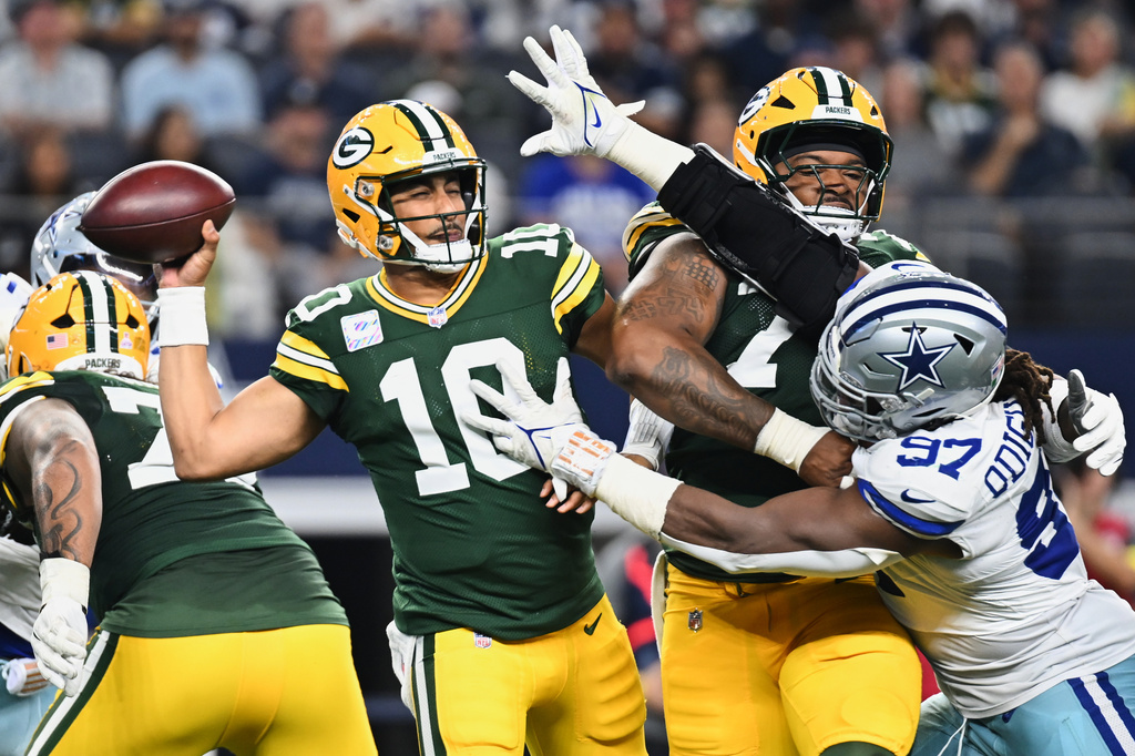 Green Bay Packers quarterback Jordan Love (10) throws a pass under pressure from Dallas Cowboys defensive tackle Osa Odighizuwa (97) in the first half of an NFL football game Sunday, Sept. 28, 2025, in Arlington, Texas. (AP Photo/Jessica Tobias)