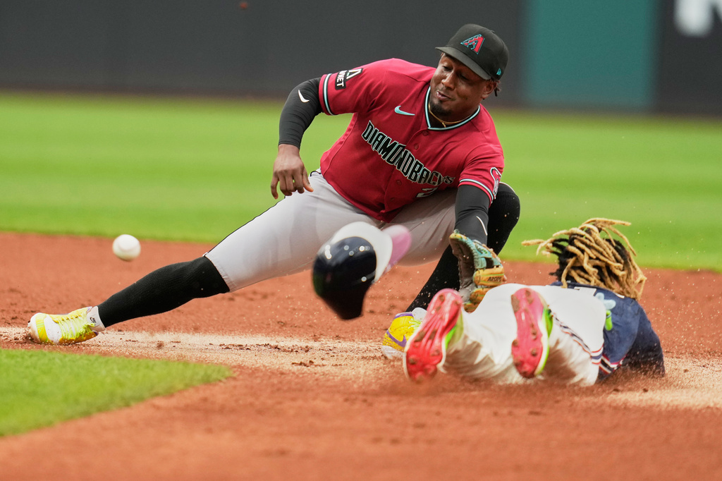 Cleveland Guardians' José Ramírez, right, steals second base on Arizona Diamondbacks shortstop Geraldo Perdomo, left, in the first inning of a baseball game in Cleveland, Friday, July 31, 2026. (AP Photo/Sue Ogrocki)