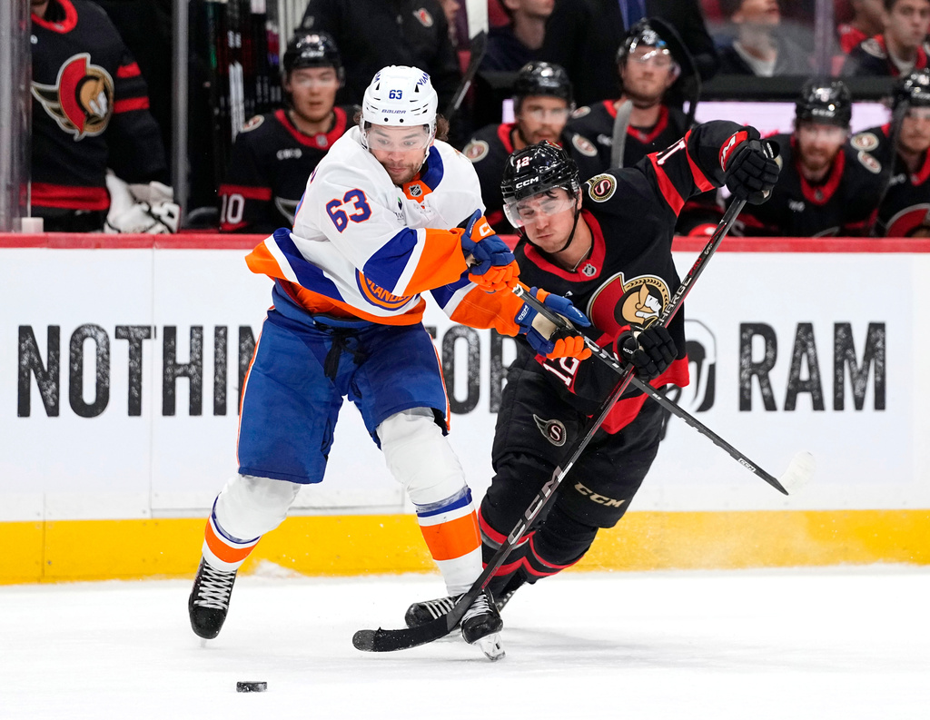 New York Islanders' Matias MacCelli (63) takes the puck from Ottawa Senators' Shane Pinto (12) during the first period of an NHL hockey game in Ottawa, Thursday, Oct. 15, 2026. (Justin Tang/The Canadian Press via AP)