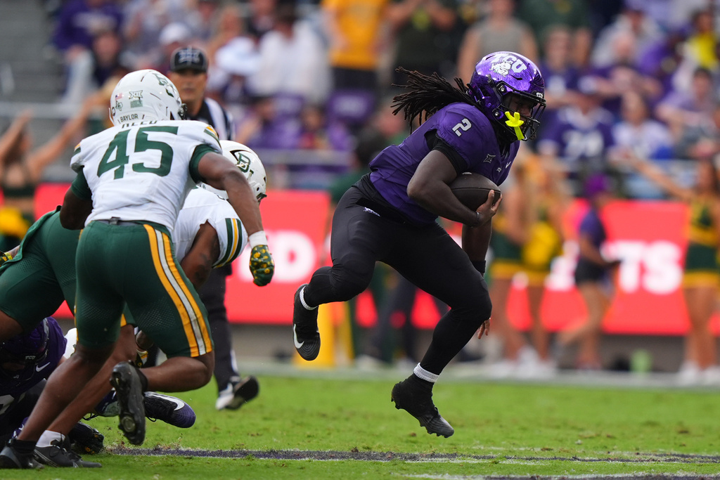 TCU running back Kevorian Barnes (2) finds space to run ahead of Baylor linebacker Kyland Reed (45) and other defenders during the first half of an NCAA college football game Saturday, Oct. 18, 2025, in Fort Worth, Texas. (AP Photo/LM Otero)
