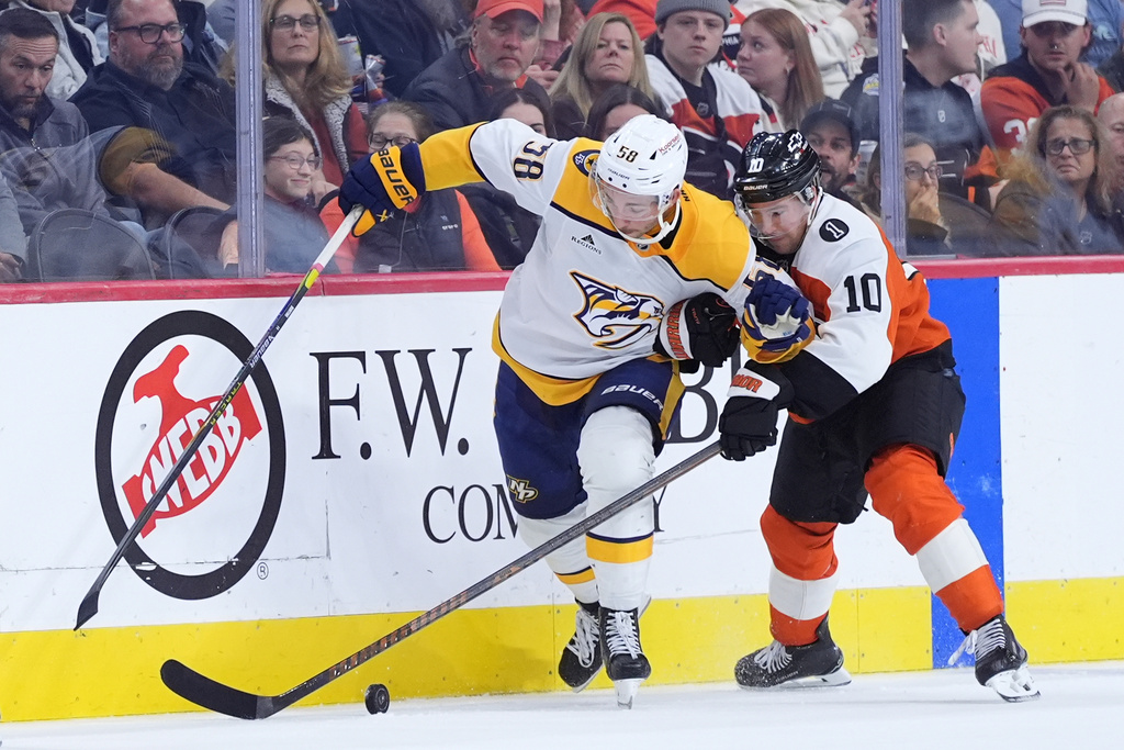 Nashville Predators' Michael Bunting, left, and Philadelphia Flyers' Bobby Brink battle for the puck during the third period of an NHL hockey game Thursday, Oct. 30, 2025, in Philadelphia. (AP Photo/Matt Slocum)