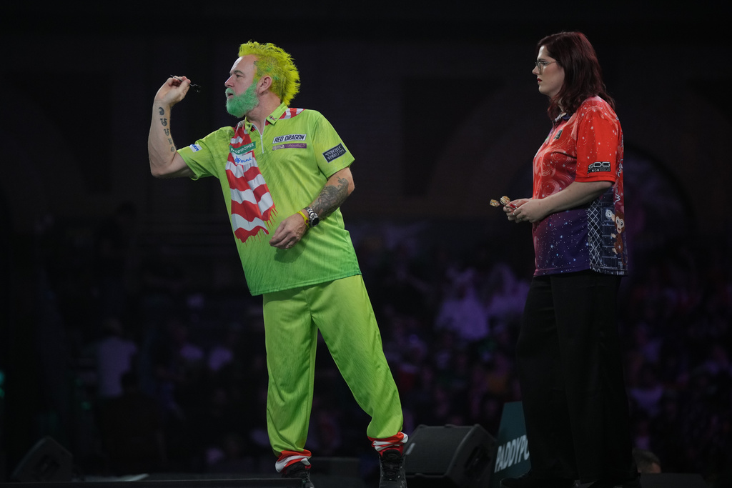 Peter Stuart Wright of Scotland throws a dart as he takes part in a round one match at the World Darts Championships, at Alexandra Palace in London, Monday, Dec. 15, 2025. (AP Photo/Kin Cheung)