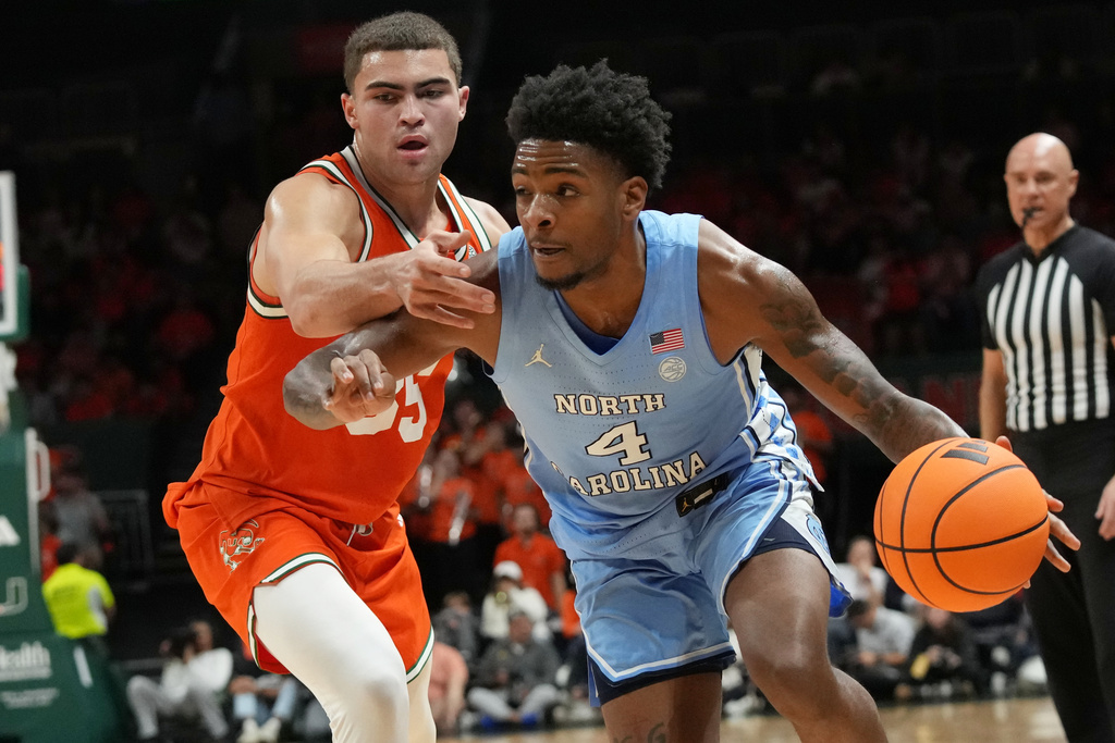 North Carolina guard Jaydon Young (4) dribbles the ball as Miami guard Dante Allen (35) defends during the first half of an NCAA college basketball game, Tuesday, Feb. 10, 2026, in Coral Gables, Fla. (AP Photo/Marta Lavandier)