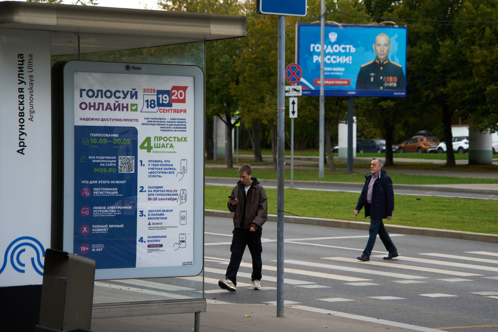 FILE - A sign reading "Vote online, reliable, affordable, simple" for Russia's parliamentary election is displayed at a bus stop in Moscow, Russia, Monday, Sept. 14, 2026, with a billboard in the background showing a soldier with the words "Russia's Pride." (AP Photo/Alexander Zemlianichenko, File)